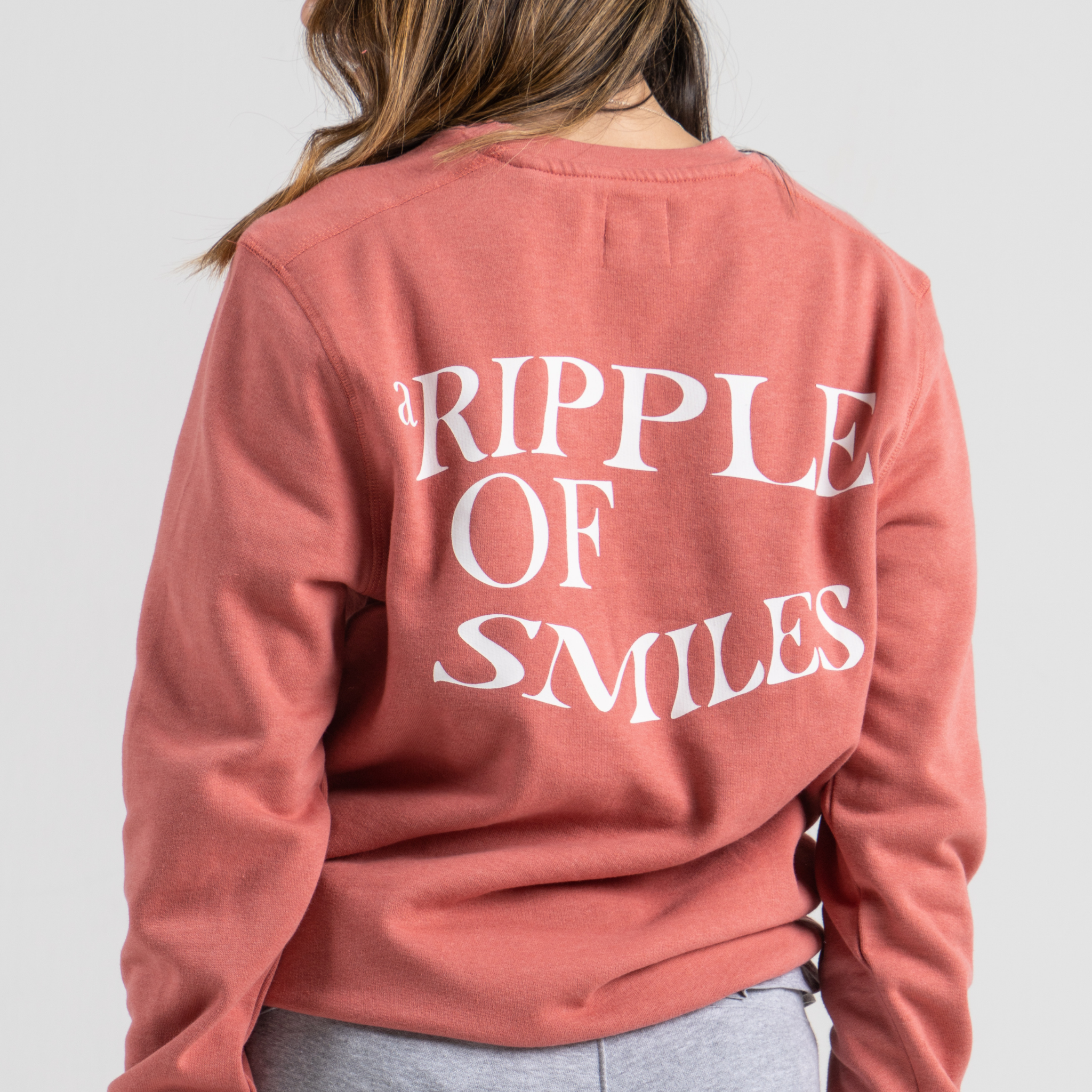Woman back wearing pink sweater SU1 clothing brand