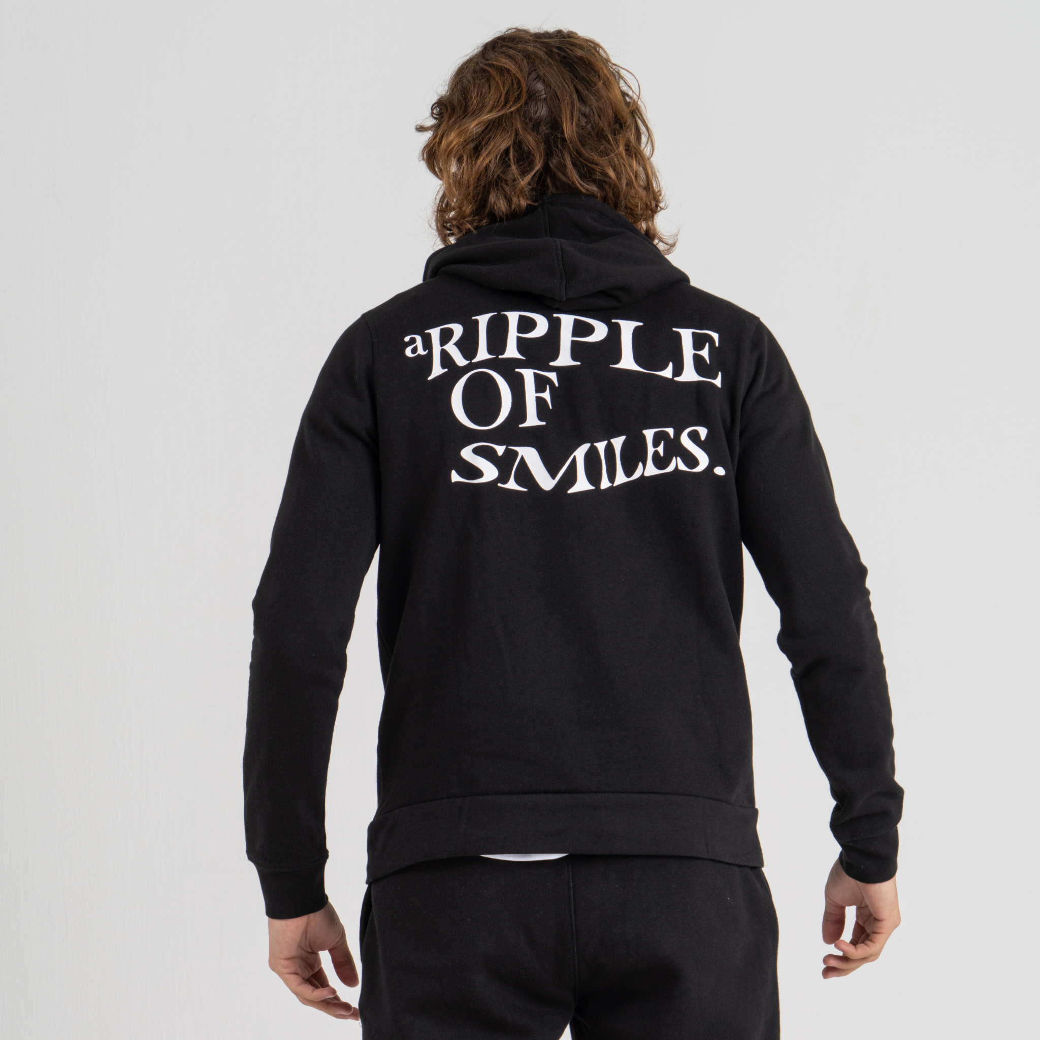 Man back wearing black hoodie SU1 brand clothing