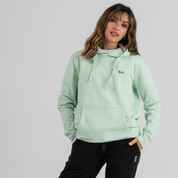 Woman wearing mint green hoodie SU1 brand clothing