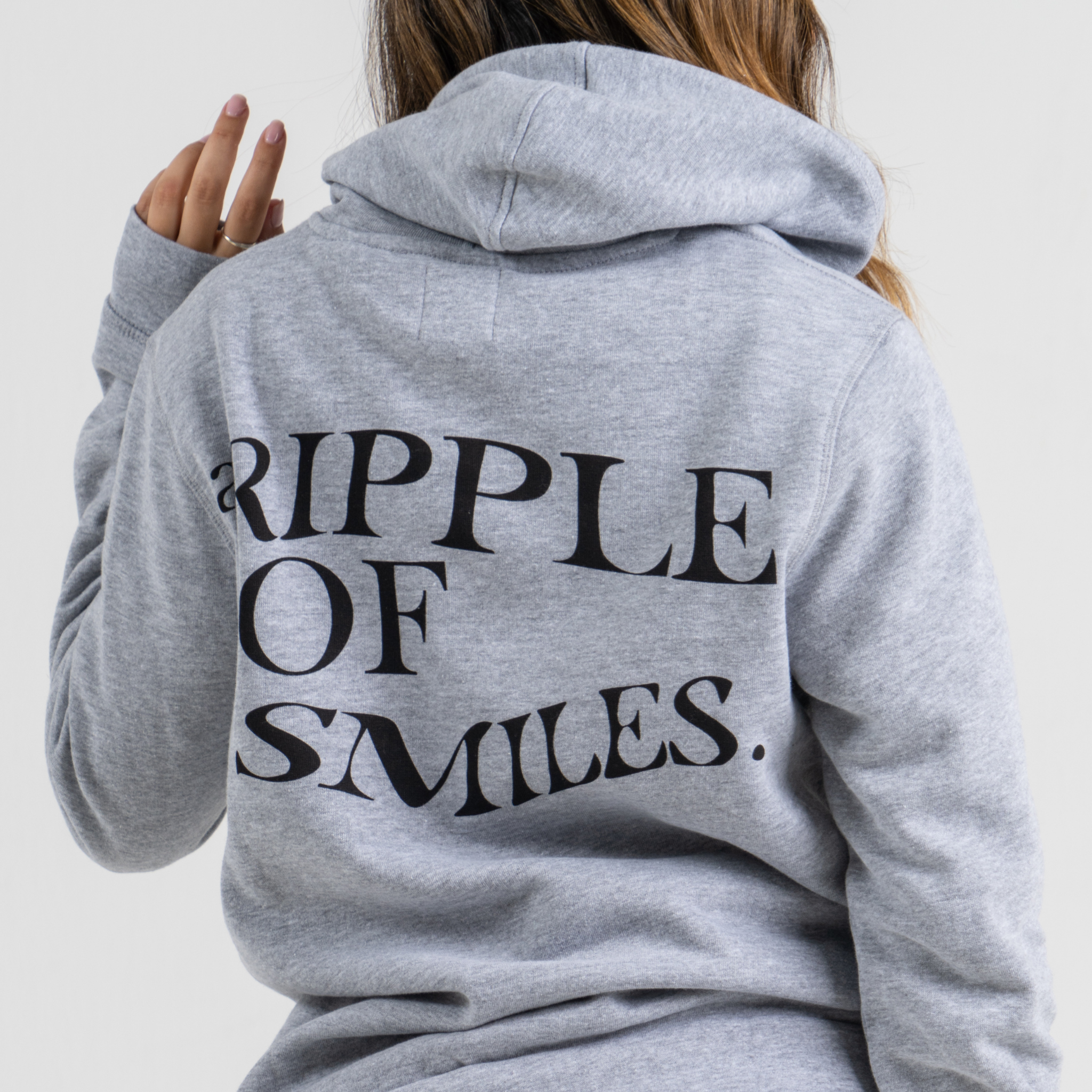 Woman back wearing grey sweater SU1 clothing brand