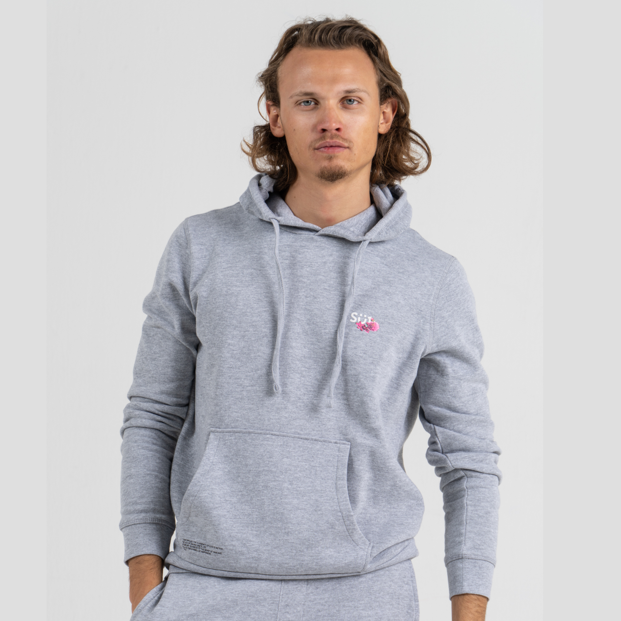 Man wearing grey sweater SU1 clothing brand