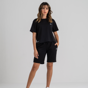 Woman wearing black mid crop tshirt and black shorts SU1 clothing brand