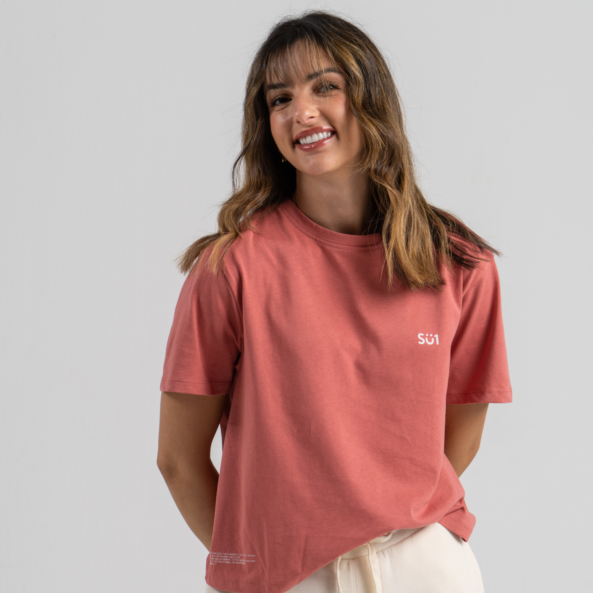 Woman wearing pink tshirt mid crop SU1 clothing brand