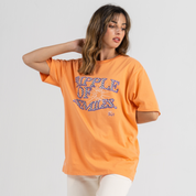 Woman wearing orange tshirt SU1 brand clothing