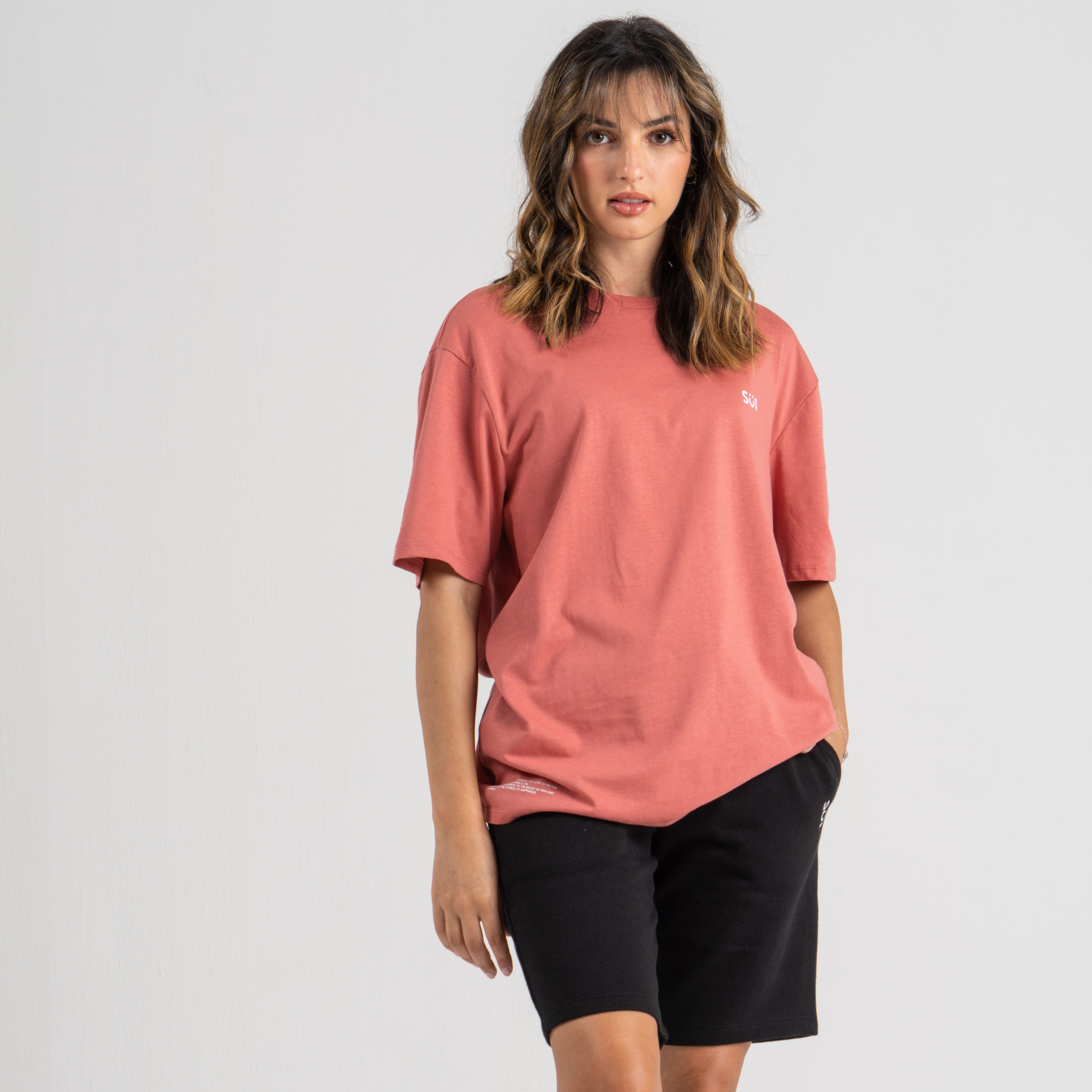 woman wearing pink t-shirt and black shorts su1 brand clothing