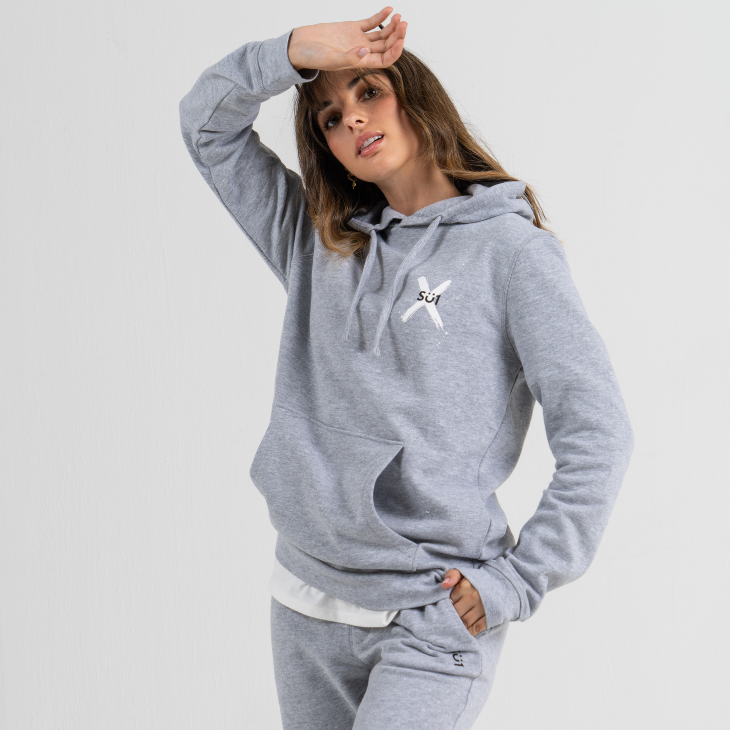 Woman wearing grey hoodie SU1 clothing brand