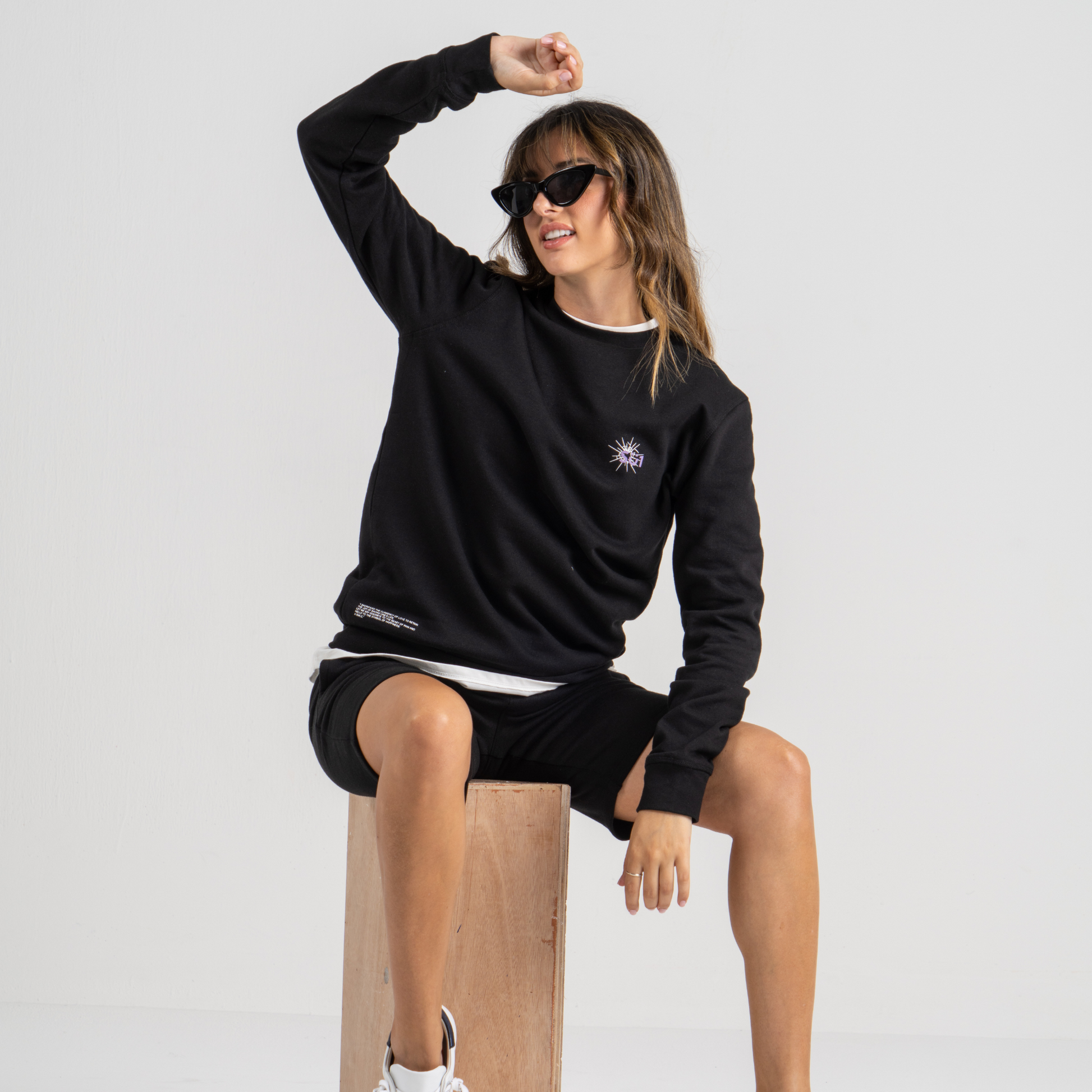 Woman wearing black sweater SU1 clothing brand and black shorts