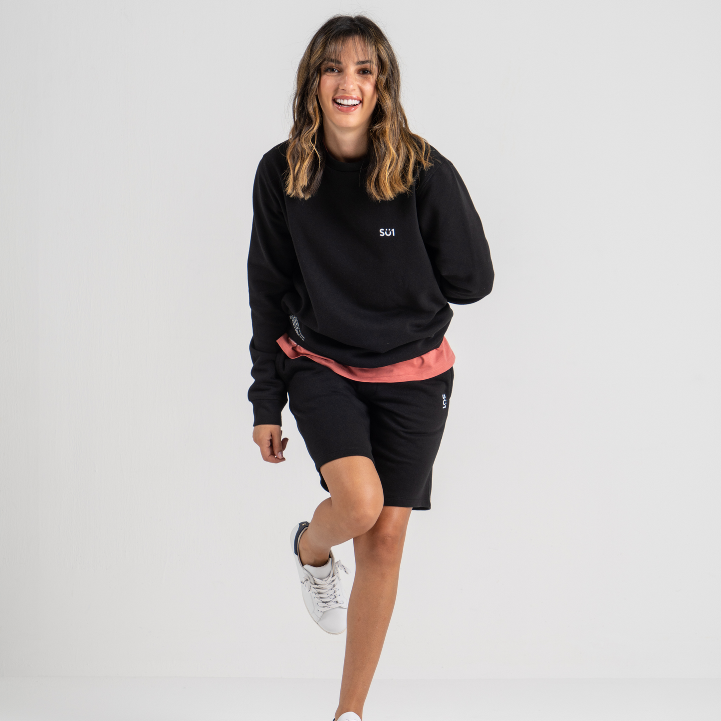 Woman wearing black sweater SU1 clothing brand and black shorts