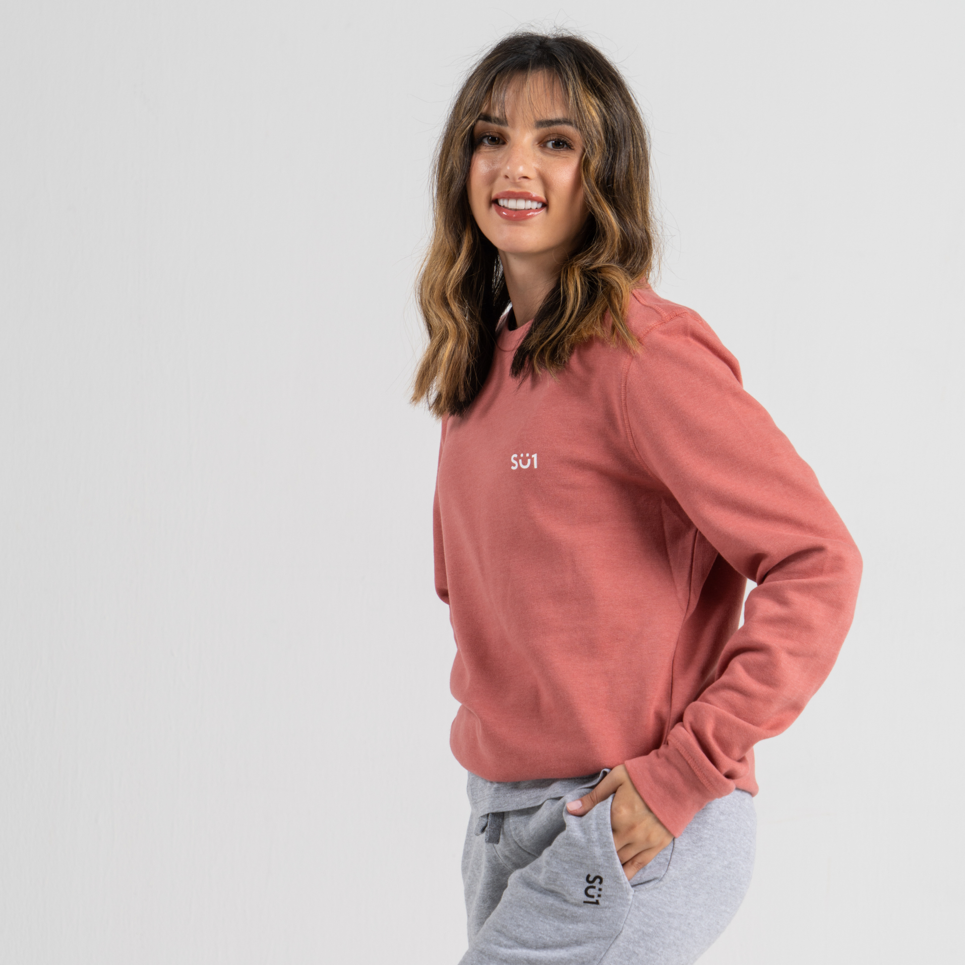 Woman wearing pink sweater SU1 clothing brand 