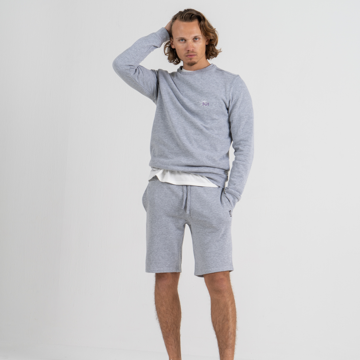 Man wearing grey sport shorts SU1 brand clothing and sweater