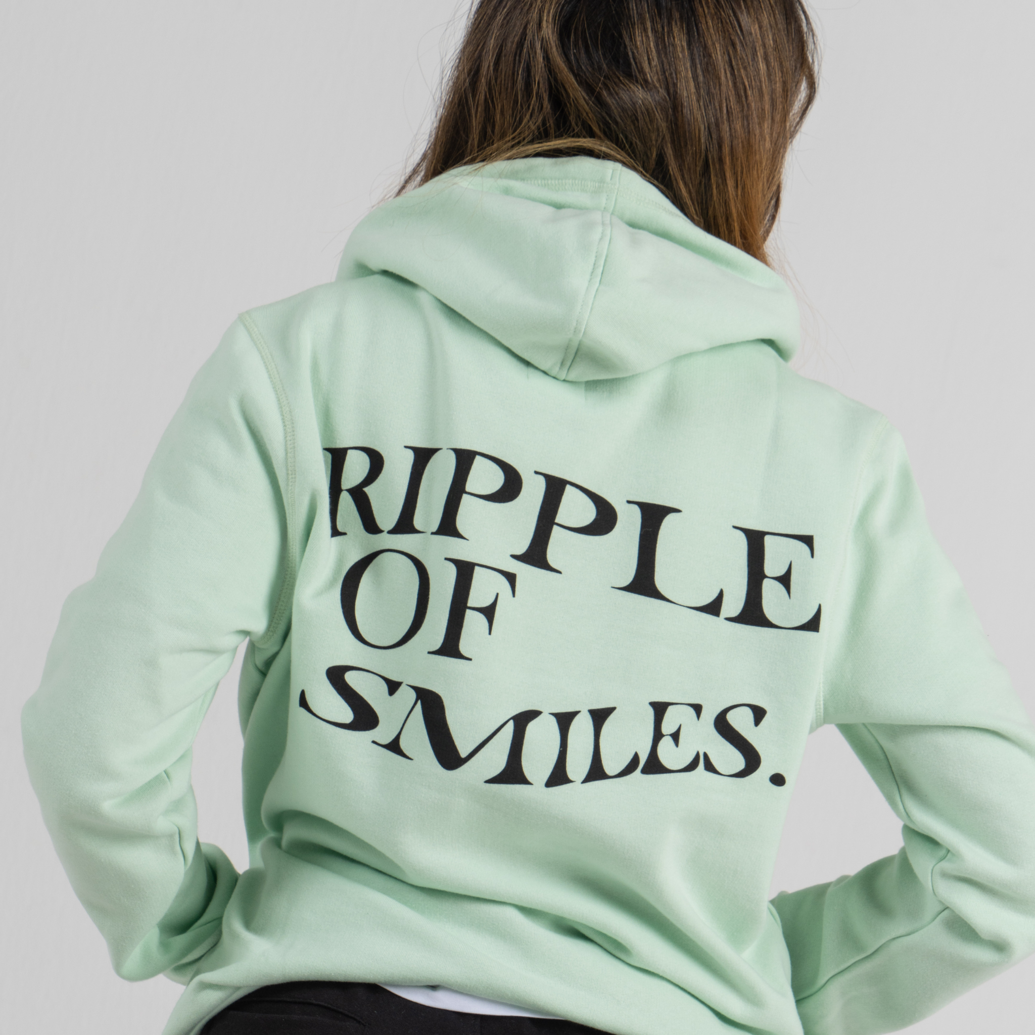 Woman wearing back mint green hoodie SU1 brand clothing 
