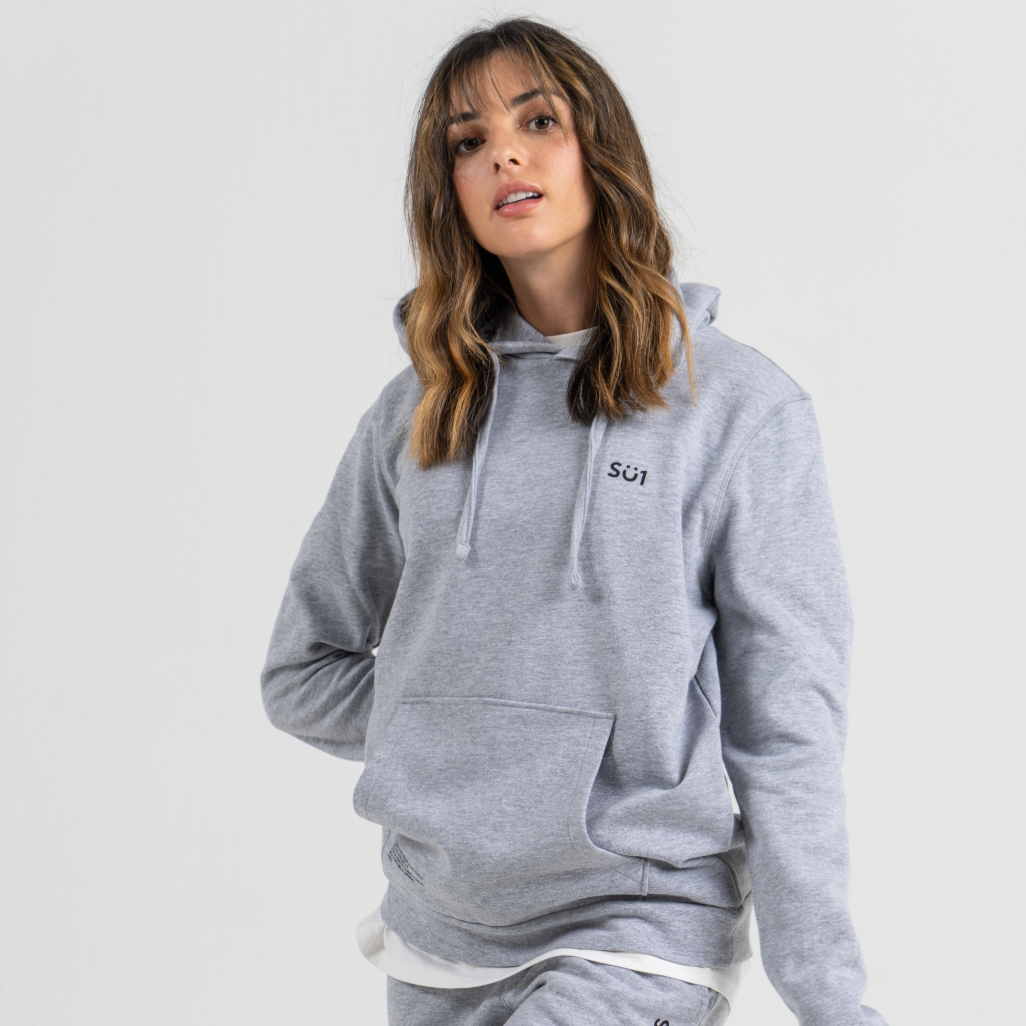 Woman wearing grey sweater SU1 clothing brand 