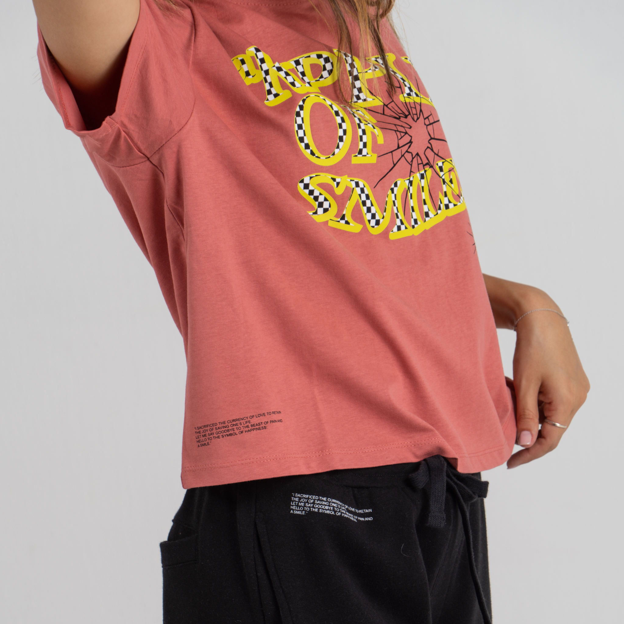 Woman wearing mid crop tshirt pink SU1 clothing brand