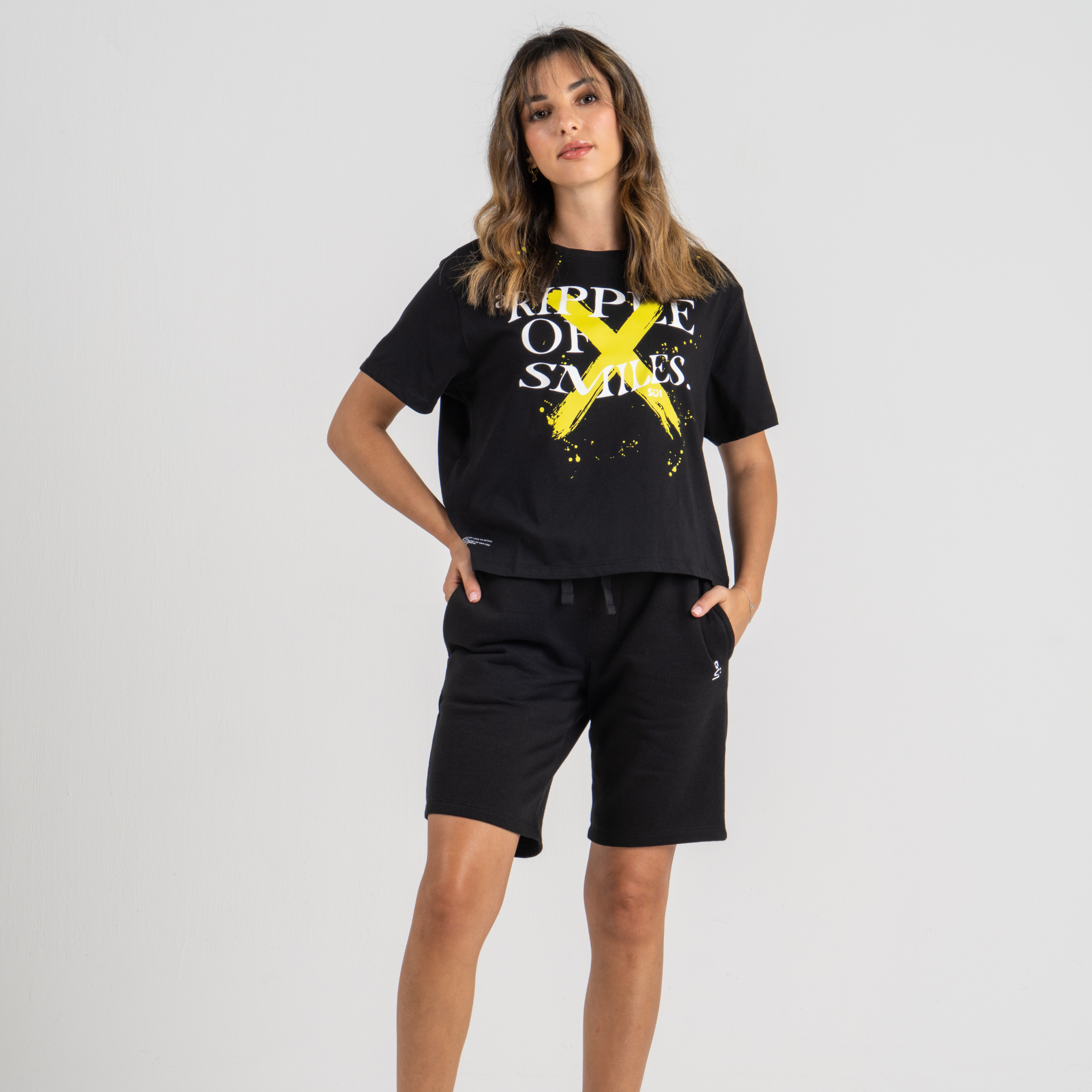 Woman wearing black tshirt mid crop SU1 clothing brand and black shorts