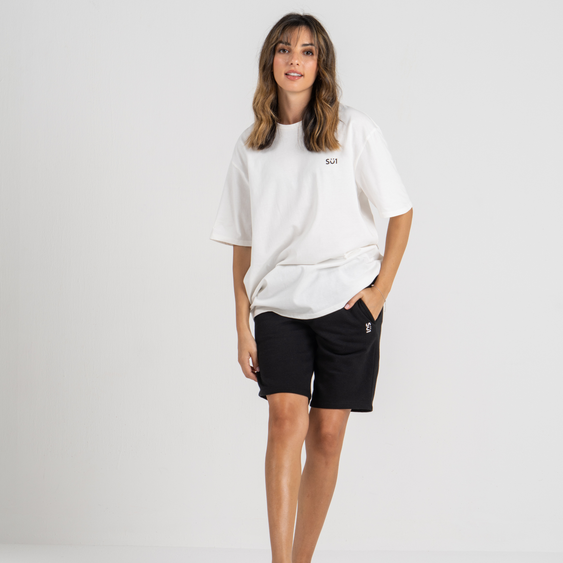 Woman wearing beige tshirt oversized with black shorts SU1 clothing brand 